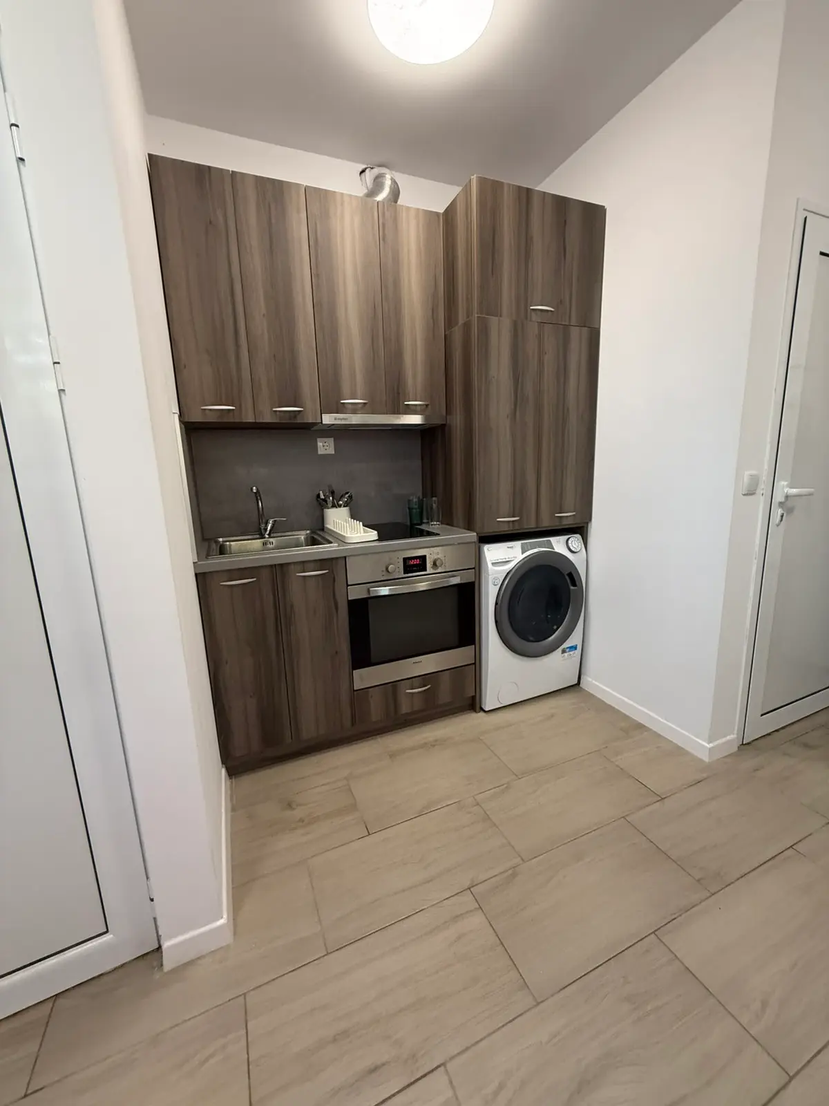 Kitchen with an oven and washing machine in an SJK Group property
